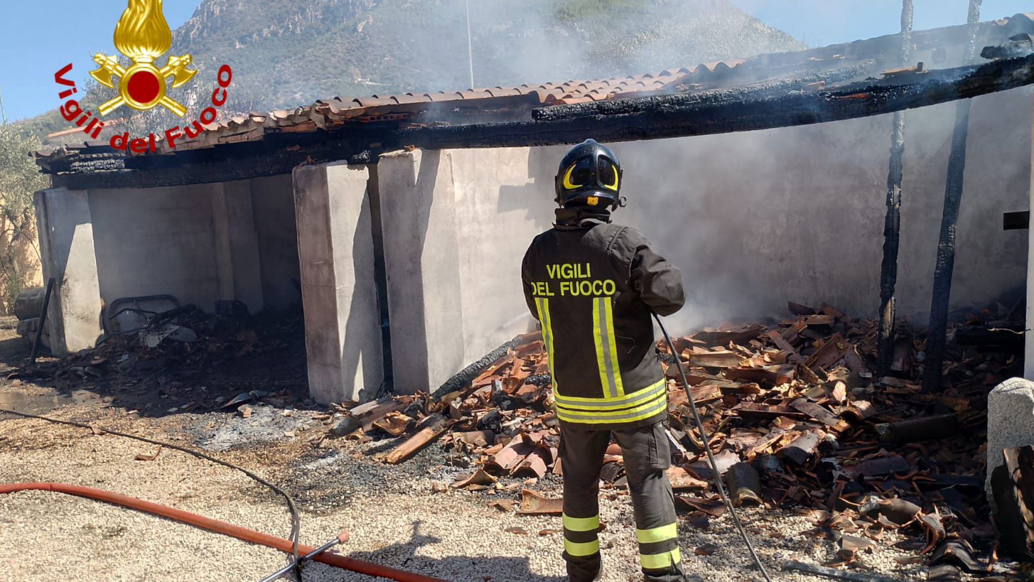 A fuoco legnaia vicino ad una casa